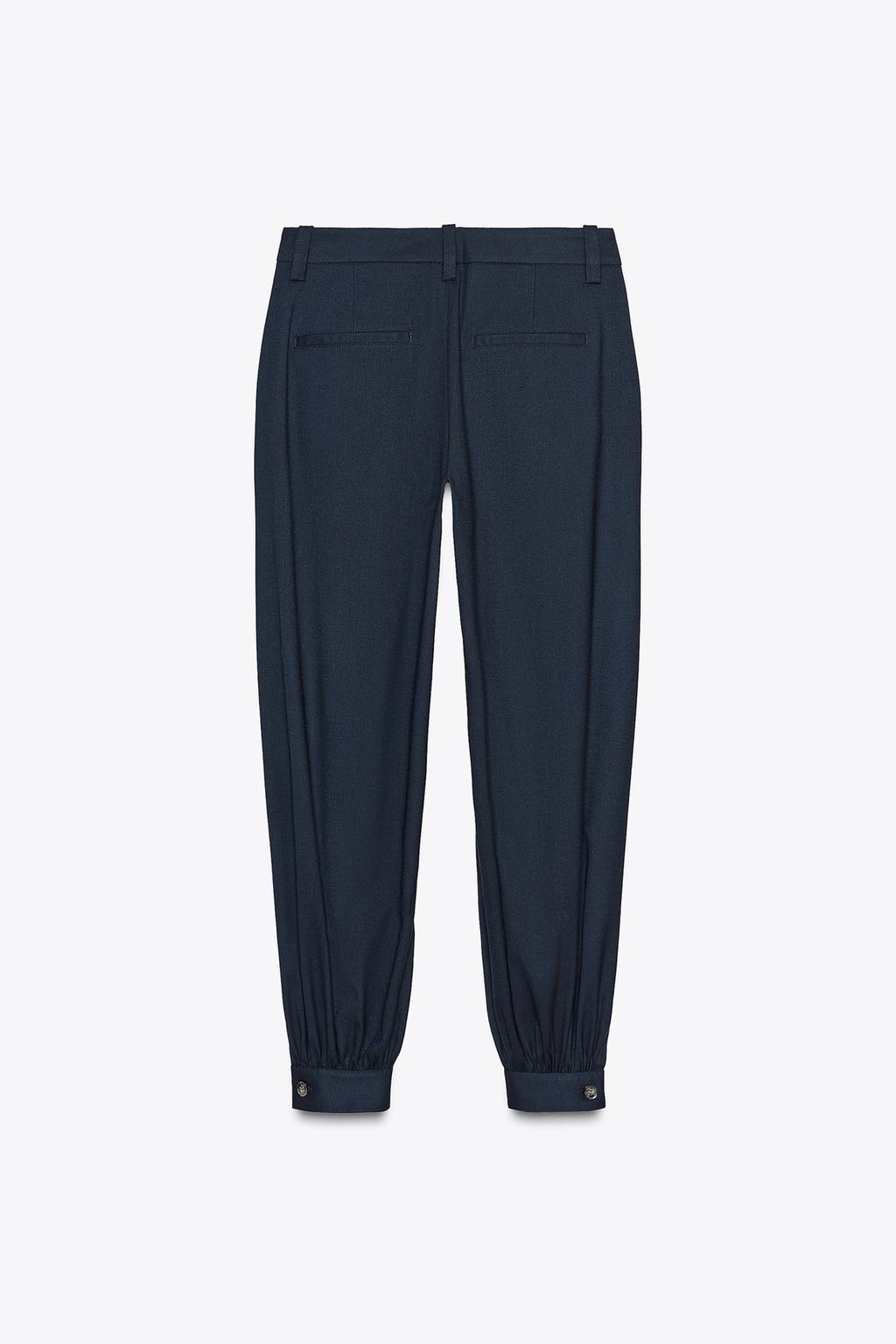 PANTALON À PINCES BAS BOUTON